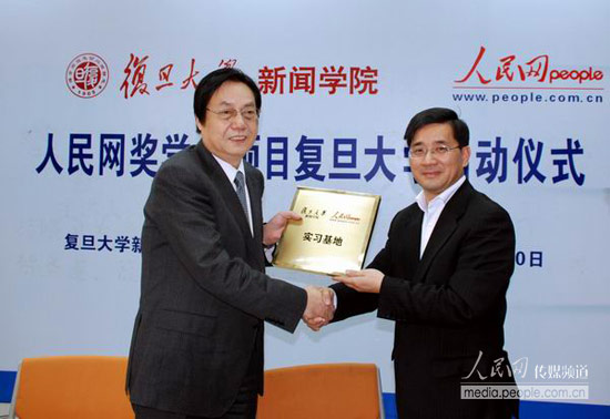 复旦大学新闻学院党委书记俞振伟（图右）向人民网颁发了“复旦大学新闻与传播学院实习基地”铜牌
