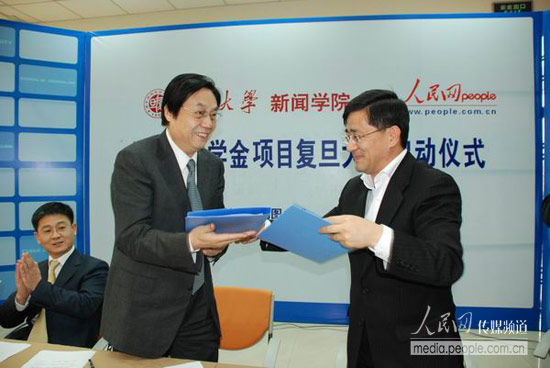 人民网何加正（图左）与复旦大学新闻学院党委书记俞振伟交换合作协议
