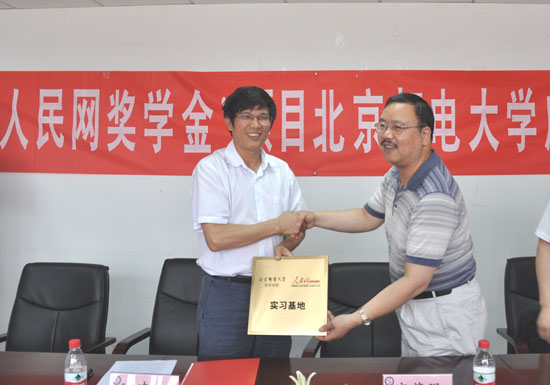 北京邮电大学软件学院党委书记刘辰（右）向官建文副总裁授予“北京邮电大学软件学院人民网实习基地”铜牌